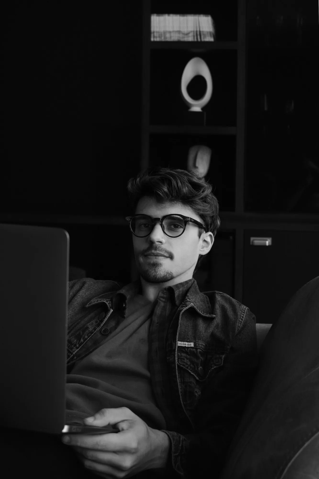 Portrait of Gustavo Tulio, UX/UI and product designer, working on a laptop